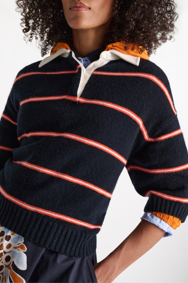 front profile model wearing Sporty Statement Sweater Energetic Blue Trio The Merino-cashmere knit top has a contrast polo collar and placket in cotton. The boxy style is cropped and has wide, elbow-length sleeves.
70 % Virgin wool (Merino), 30 % Cashmere
Two-tone fine stripe Merino-cashmere knit top with polo collar
Cotton collar and button placket with topstitching
Hidden button closures