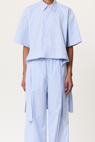 front profile model wearing striped belted shirt  blue white stripe Popover style
Classic Collar
Cotton Poplin&nbsp;
Thick waist tie detail
Short sleeve
Long back