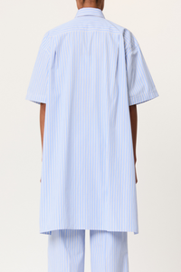 back profile model wearing striped belted shirt  blue white stripe Popover style
Classic Collar
Cotton Poplin&nbsp;
Thick waist tie detail
Short sleeve
Long back