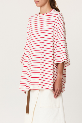side profile model wearing  Striped Oversized Tee red white stripe White/Red wide sleeved t-shirt
Red heat-sealed Bianca patch on the back
Loose fit
100% cotton