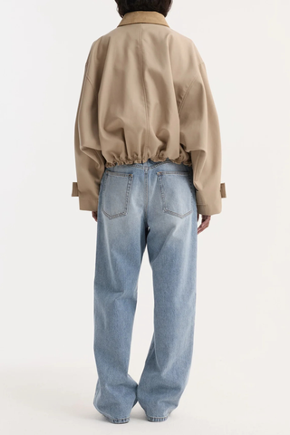 back profile model wearing  Suede Collar Blouson Jacket sand beige Cropped trench-inspired bomber
Suede collar
Dropped shoulders
Wide sleeves
Sleeve straps with button closures cotton