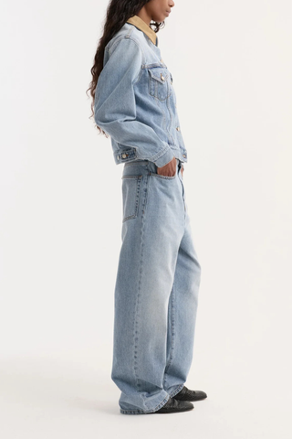 side profile model wearing  Suede Collar Denim Jacket classic blue light wash Classic fitted denim jacket
Contrasting suede collar
Chest pockets
cotton