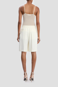 back profile model wearing Tailored Fluid Twill Short ivory Recycled fluid wool fabrication
Knee length
Elasticated back waistband
Zip fly with hook &amp; bar closure
Front pleats
Side pockets
Back jet pockets