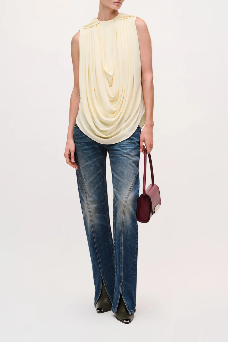 front profile model wearing  The Astor Draped Jersey Top Butter Cascading folds
Sleeveless
Deep cowl-neck draping
Fitted silhouette through the waist
100% Viscose Jersey
