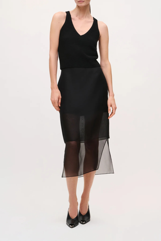 front profile model wearing The Brett Pencil Skirt Black  Silk crepe de chine skirt
Sheer silk organza lower panel
Slim pencil silhouette
Midi length
Concealed center back zip closure with hook-and-eye
Baby-hem finish on organza
