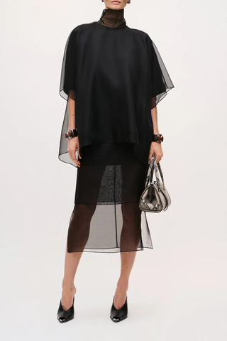 front profile model wearing The Cali Organza Blouse With Neck Tie Oversized blouse
Sculptural volume
Integrated scarf neckline
Coordinating satin camisole
Refined interplay of sheer and opaque for a modern, elegant finish
100% lightweight silk organza
