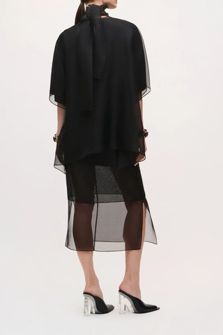 back profile model wearing The Cali Organza Blouse With Neck Tie Oversized blouse
Sculptural volume
Integrated scarf neckline
Coordinating satin camisole
Refined interplay of sheer and opaque for a modern, elegant finish
100% lightweight silk organza