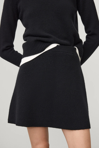 front profile model wearing The Clare Skirt Black cashmere mini length regular fit slightly flared elastic waistband