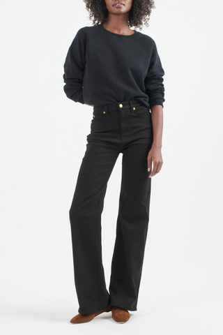 front profile model wearing The Crease Jean Black wash relaxed narrow flare
