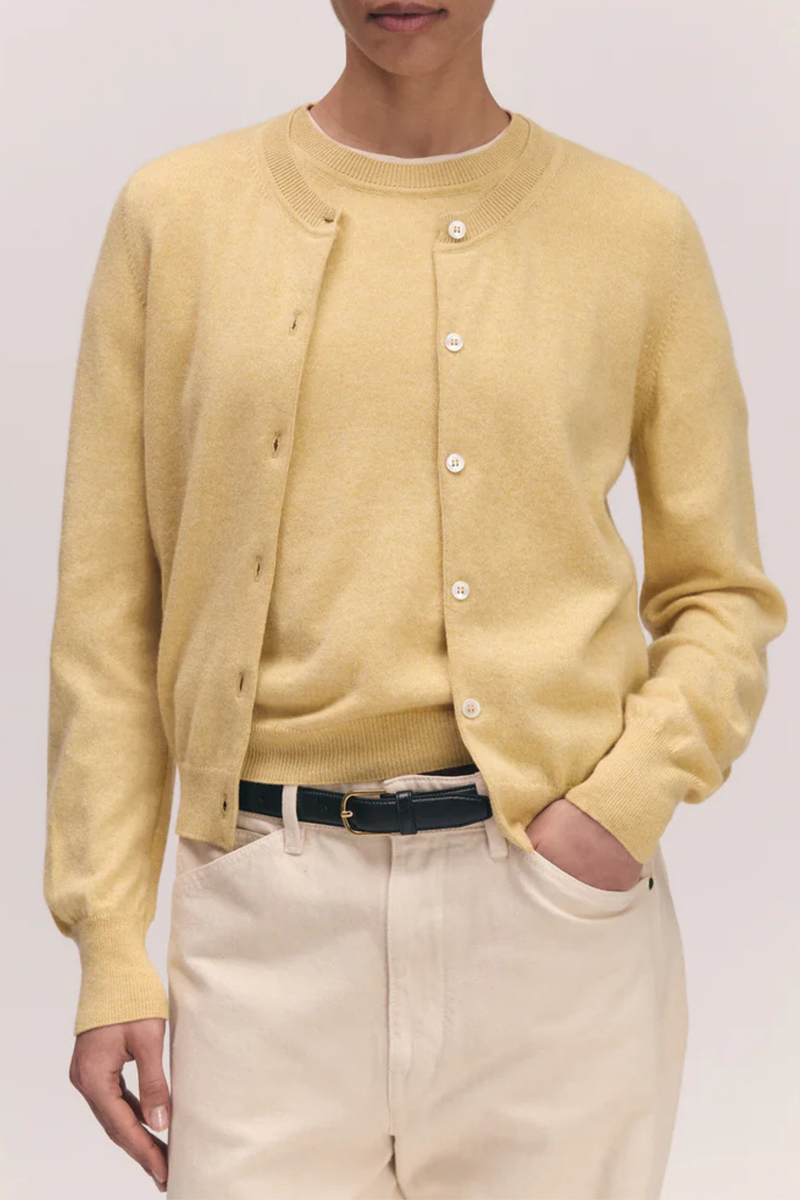front profile model wearing The Enya Cashmere/Cotton Cardigan pale yellow, crewneck, ribbed hem and cuff, button front closure