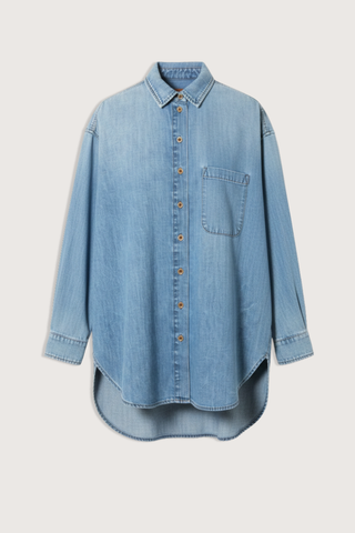 flat lay The Essential Denim Shirt worn indigo mid wash blue relaxed shape
Button at the chest 
Button under the neckline 
Small button perfectly placed on the hidden cuff placket 
100% Cotton
Medium faded vintage inspired indigo 