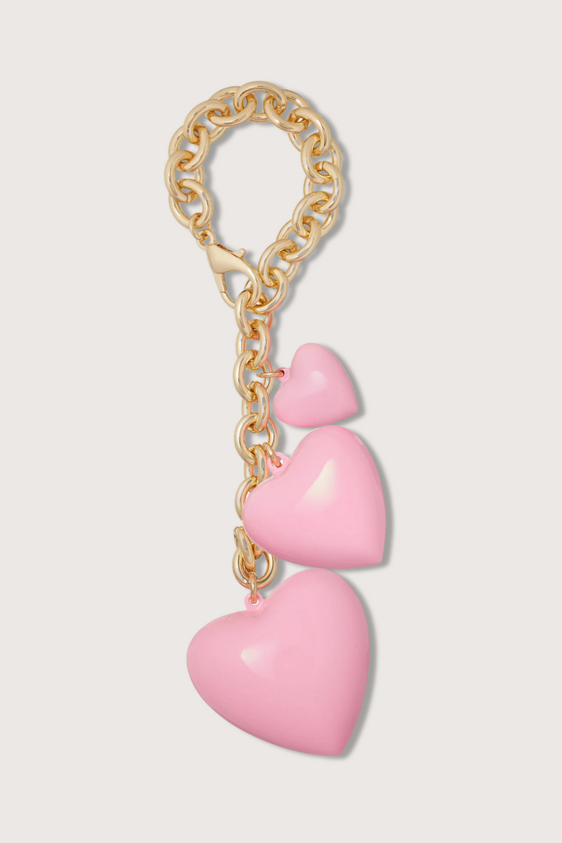flat lay The Happy Bag Charm Pink puffy heart with gold chain