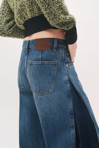 close up side profile of back pocket The Lana Trouser Denim bi-color blue mid wash
Wide-leg
Split seam construction
Integrated side pleats 
Classic five-pocket construction
Back darts in place of a traditional denim yoke
Brown denim back patch
Zip fly with button closure
100% Cotton