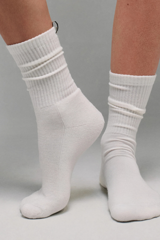 front profile model wearing The Merino Tube Sock Off White 
68% Merino Wool, 30% Nylon, 2% Elastane
Terry cushioned footbed
With logo ribbon tab