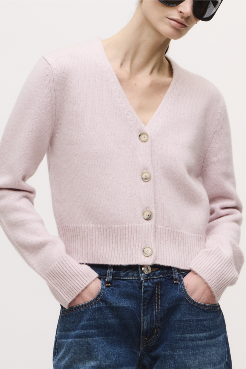 front profile model wearing  The Sloane Cardigan Dusty Pink V-NECKLINE
4 BUTTON CLOSURE
14% SILK, 86% CASHMERE
