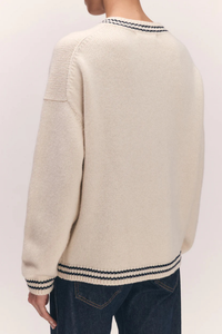 back profile model wearing The Stripe Trim Balla V-Neck Sweater lambswool white with navy stripe detail on neck, hem and cuff 