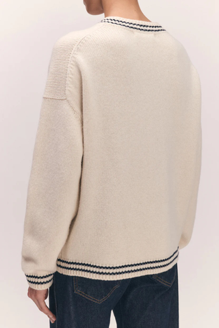 back profile model wearing The Stripe Trim Balla V-Neck Sweater lambswool white with navy stripe detail on neck, hem and cuff 