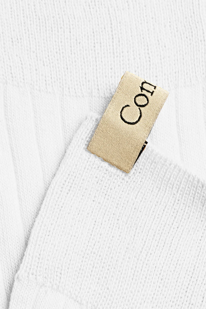 close up of logo tab for The Yves Sock White cotton ribbed