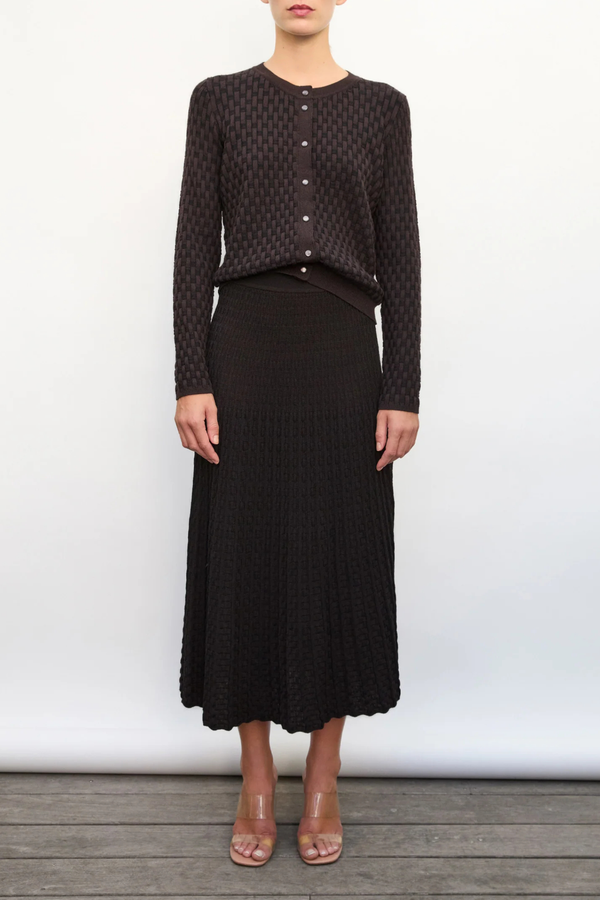front profile model wearing Thelma Skirt ebony deep black Two-tone
Pleated “arrow”-patterned knit
Mid-length cut
Wicker-style knit skirt
High waist
Wide scalloped waistband
50% viscose, 45% pure extra-soft virgin wool, 5% polyester