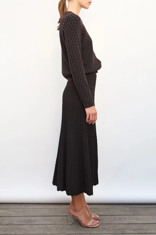 side profile model wearing Thelma Skirt ebony deep black Two-tone
Pleated “arrow”-patterned knit
Mid-length cut
Wicker-style knit skirt
High waist
Wide scalloped waistband
50% viscose, 45% pure extra-soft virgin wool, 5% polyester