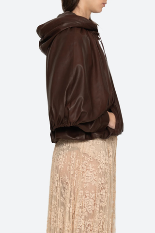 side profile model wearing Thompson Leather Cape Jacket brown 
bubble hem
Adjustable drawstrings
attached hood
Self-100% lamb leather | Lining-100% polyester
Front zipper
Oversized, relaxed fit
100% Lamb Leather