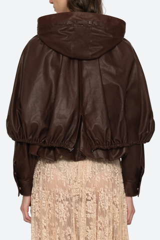 back profile model wearing Thompson Leather Cape Jacket brown 
bubble hem
Adjustable drawstrings
attached hood
Self-100% lamb leather | Lining-100% polyester
Front zipper
Oversized, relaxed fit
100% Lamb Leather