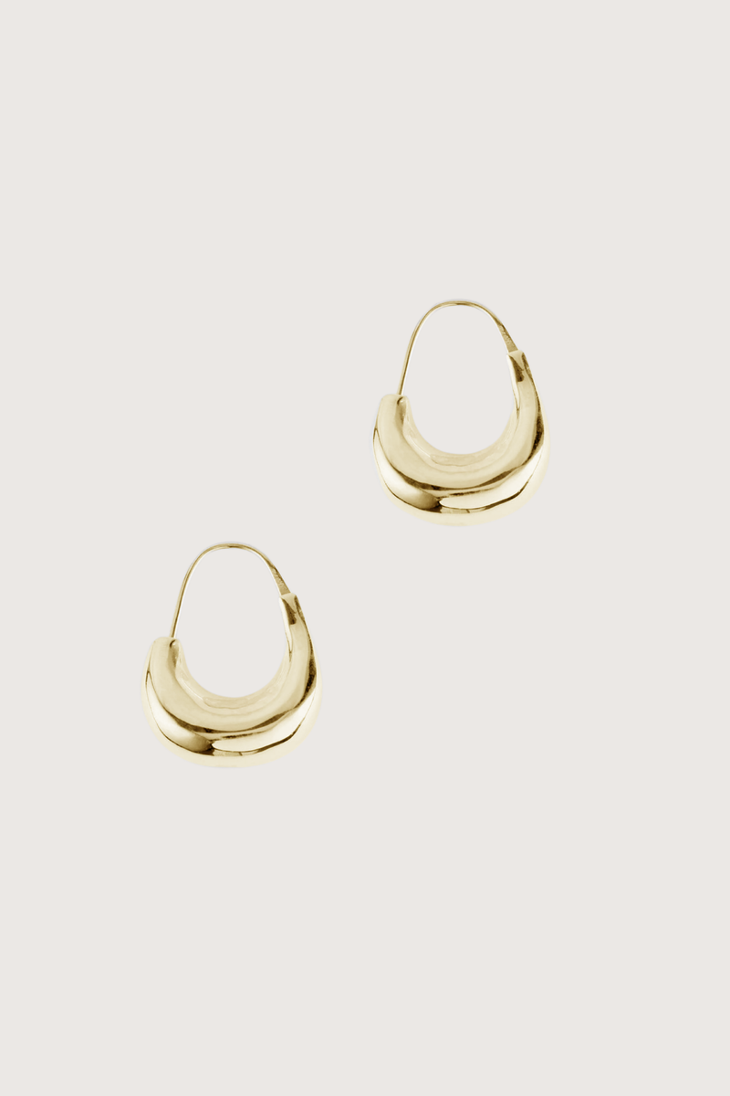 flat lay Tide Hoops Earring Gold Small irregular loop
Weighted and organic form that curls just below the lobe
Sterling silver and plated in 18k yellow gold
Earring length approximately 2.8cm