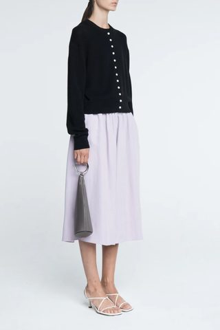 side profile model wearing Tiny Button Cardigan Black Relaxed fit
Drop shoulder tiny shell buttons at the center front
Long sleeve cardigan
 Cashmere  Cotton blend