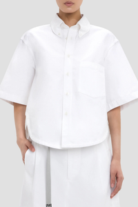 front profile model wearing Trapeze Short Sleeve Shirt optical white Collared neckline
High hip length
Shirt sleeves
Covered back
Chest pocket
Front buttons
100% Cotton