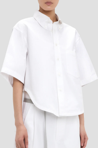 side profile model wearing Trapeze Short Sleeve Shirt optical white Collared neckline
High hip length
Shirt sleeves
Covered back
Chest pocket
Front buttons
100% Cotton