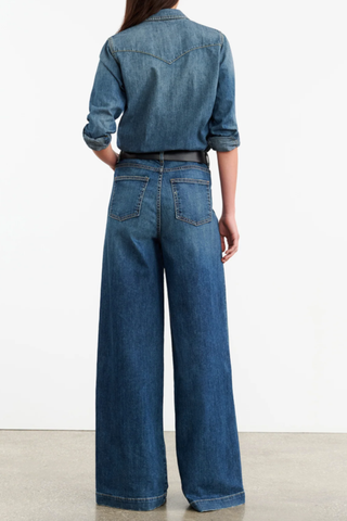 back profile model wearing Travis Denim Shirt medium blue wash classic straight fit collar jean shirt center front pockets