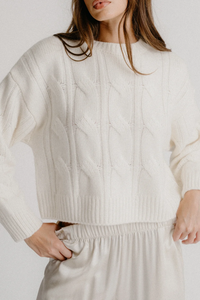 front profile model wearing Tristan Crewneck Cable knit sweater Gardenia white cashmere