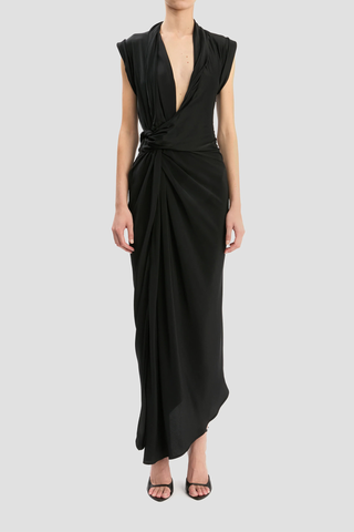 front profile model wearing Twist Detail CDC Dress Black Asymmetric, drape midi dress
High shine jersey bodice
Crepe de chine skirt
Wrap front neckline with button &amp; thread loop closure
Short roll sleeve
Twist drape waist detail
Front skirt split
Concealed side zip