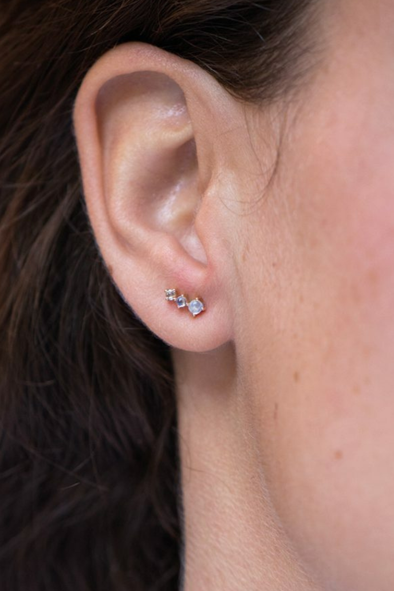 model wearing 14k light yellow gold earrings
Two moonstones
One rose cut diamond
The stones come in a gradient of light iridescent tones