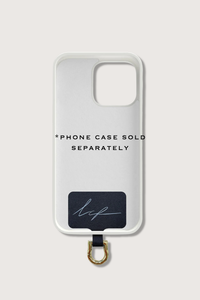 flat lay of Universal Adapter Made of fabric with a stainless steel coating gold with example phone case