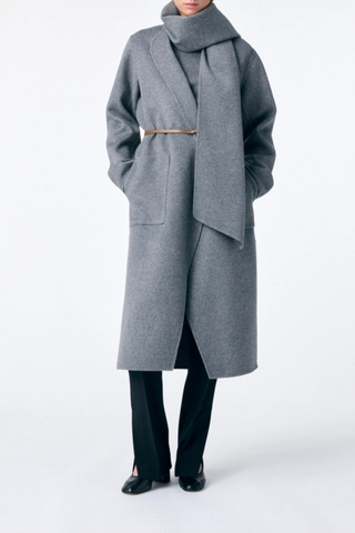 front profile model wearing Valeran Coat With Scarf Grey Long length coat
Removable scarf 
Removable belt
Asymmetrical panels allow
Patch pockets at the front
Large slits at the sides
80% Wool 20% Polyamide