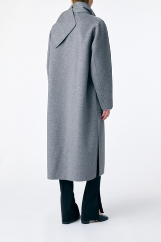 back profile model wearing Valeran Coat With Scarf Grey Long length coat
Removable scarf 
Removable belt
Asymmetrical panels allow
Patch pockets at the front
Large slits at the sides
80% Wool 20% Polyamide