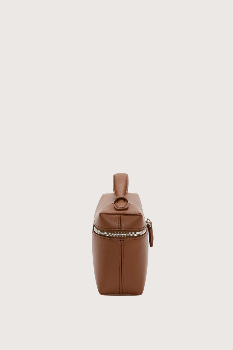 side profile Vanity Crossbody Bag tan 
Top handle
Removable crossbody strap
Microsuede lining
Top handle functionality
Zip closure
100% Calf Leather