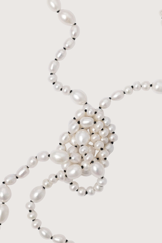 close up pearl and black silk thread detail  for Veil Pearl Necklace Irregular shaped pearls
Threaded and knotted onto a contrasting black silk
Can be worn doubled around the neck, crossed over the body as a sash from the sea, or crafted into a belt to provide luster and accent to layered fabric
Baroque pearls and black silk
Necklace measures 1.2 meters in length