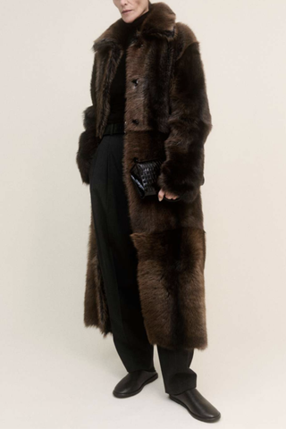 front profile model wearing Verena Toscana Long Coat dark brown Reversible shearling coat
Snap button closure
100% lamb leather
Long length
Reversible option: soft shearling side &amp; smooth leather side