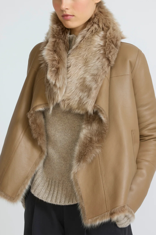 front profile model wearing leather side Veste Reversible Fur Jacket Chai Latte beige Unlined Toscana lambskin
Two piped pockets
Front hook-and-eye fastening
Draped collar
Long-haired lamb
Wide cut
100% Lamb