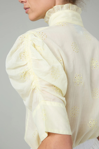 close up sleeve detail of Vita Embroidered Voile Short Sleeve Top yellow Embroidery throughout
Puff sleeves
Ruched sleeves with thick cuffs
High collar with ruffles
Button front

Side slit
100% Cotton