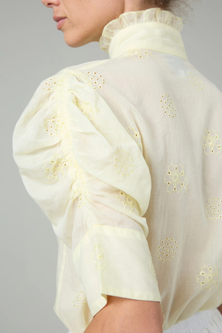 close up sleeve detail of Vita Embroidered Voile Short Sleeve Top yellow Embroidery throughout
Puff sleeves
Ruched sleeves with thick cuffs
High collar with ruffles
Button front

Side slit
100% Cotton