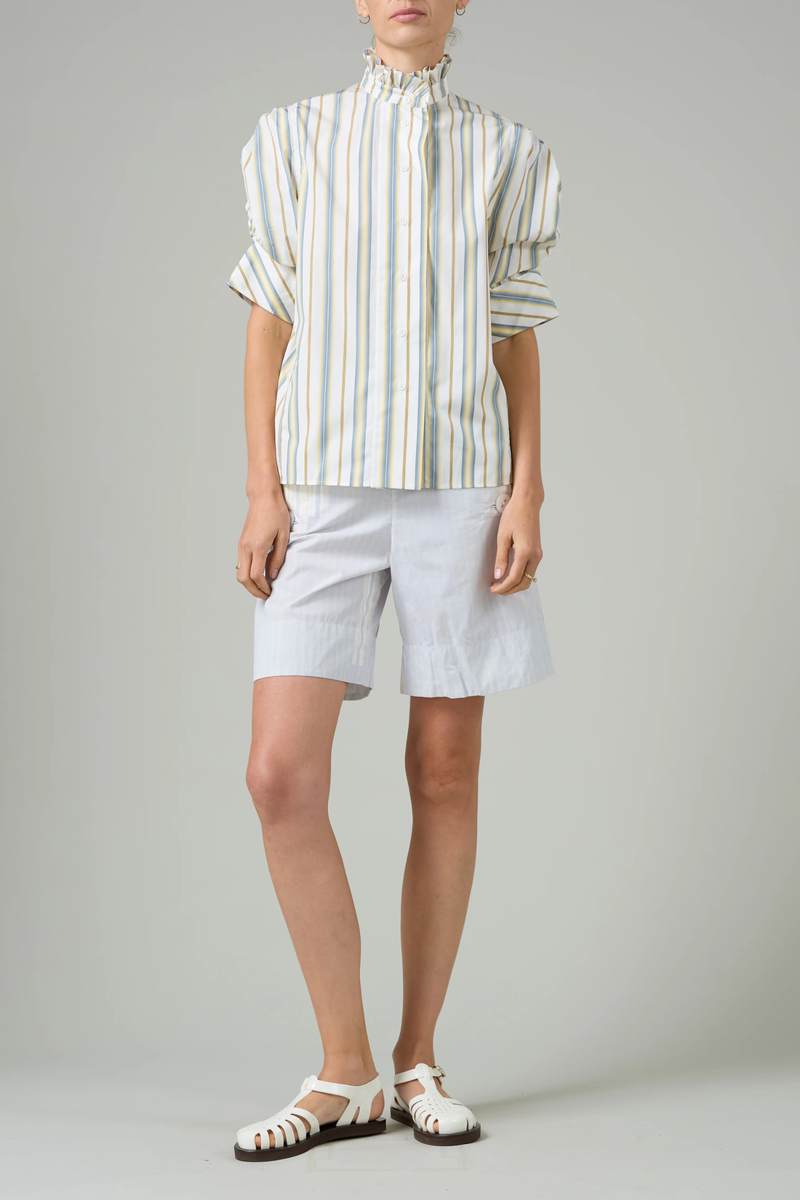 front profile model wearing Vita Stripe Short Sleeve Top yellow grey stripe Puff sleeves
Vertical stripe pattern
Ruched sleeves with thick cuffs
High collar with ruffles
Button front

Side slit
100% Cotton