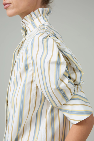 close up sleeve detail for Vita Stripe Short Sleeve Top yellow grey stripe Puff sleeves
Vertical stripe pattern
Ruched sleeves with thick cuffs
High collar with ruffles
Button front

Side slit
100% Cotton