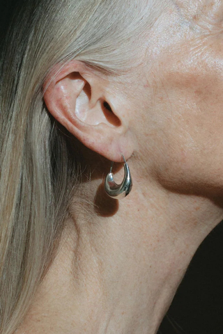 model wearing Wave Hoops Earring Rounded high-gloss wave shapes
Swing from the lobe
Rolling light around their bulbous forms
Sterling silver and plated in rhodium Earring
Length approximately 3.8cm