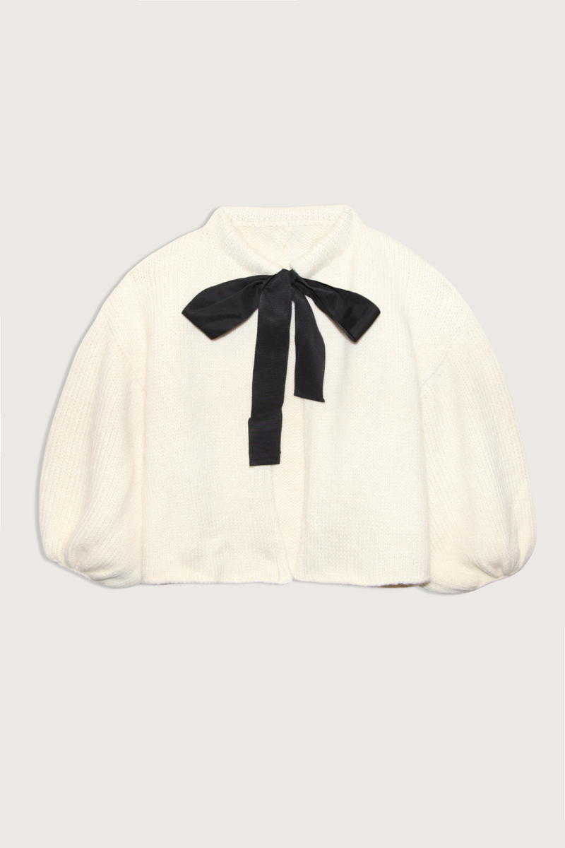 flat lay Wool/Cashmere Bow Cardigan ivory Open cardigan
Black ribbon bow connecting top collar
Bubble sleeve
Crewneck
65% Merino Wool, 30% Cashmere, 5% Nylon