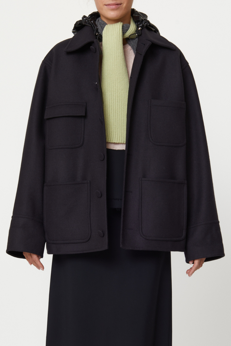 front profile model wearing Wool Hooded Jacket black Double wool cargo jacket, Four front pockets, Covered buttons, Detachable black shiny hood