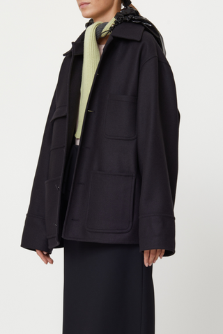 side profile model wearing Wool Hooded Jacket black Double wool cargo jacket, Four front pockets, Covered buttons, Detachable black shiny hood