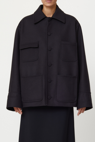 front profile model wearing detached shiny hood Wool Hooded Jacket black Double wool cargo jacket, Four front pockets, Covered buttons, Detachable black shiny hood